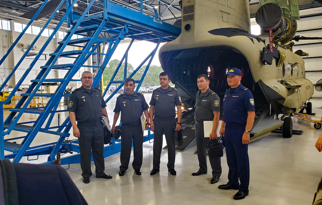 a picture of five man in uniform standing in front of an aircraft