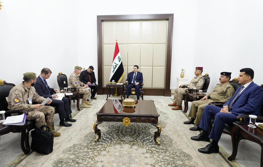 a picture of soldiers and government officials sitting in a white conference room