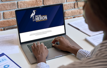 a picture of a woman viewing the latest ISG Heron on her laptop