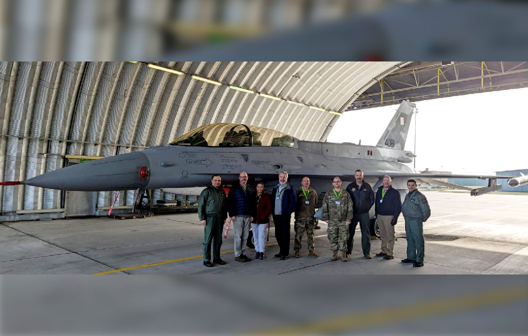 a group of men standing in front of a jet