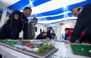 A picture of soldiers hovering over the table strategizing and exchange expertise and best practices in disaster response