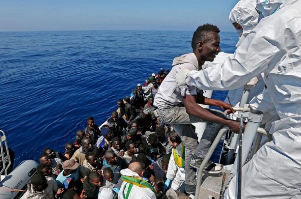 Migrant being helped out of boat