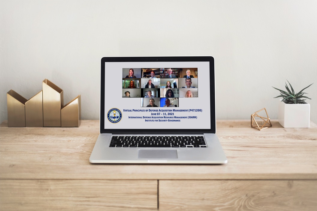 A desktop with a laptop open. On the screen is a snapshot of members participating in a virtual meeting